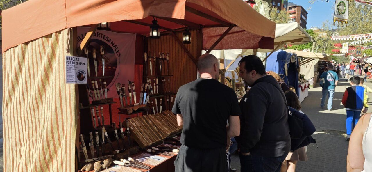 Personas interactuando en un mercado romano con productos artesanales.