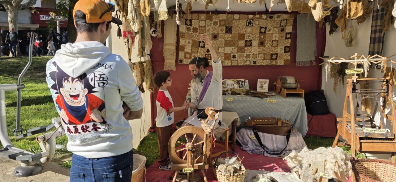 Persona enseñando a un niño a hilar en un mercado romano