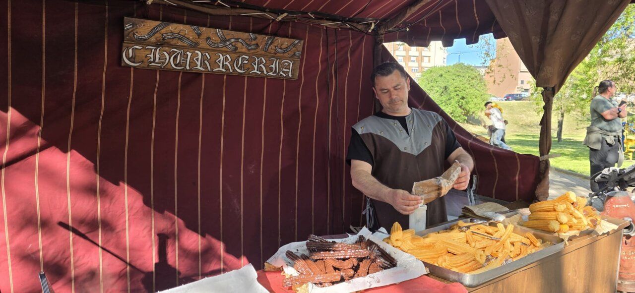 Vendedor en un mercado romano preparando churros en Ponferrada.