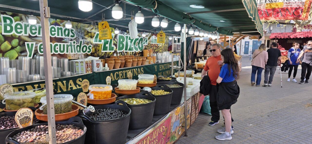 Puesto de mercado con aceitunas y encurtidos en un evento romano