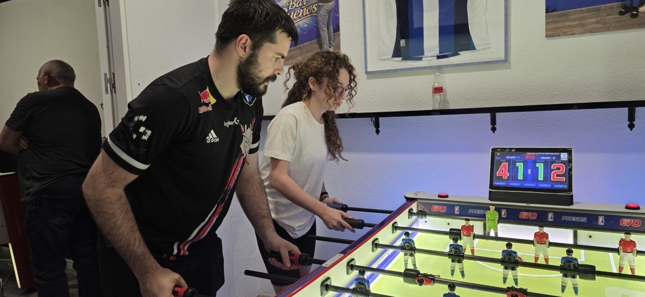 Jugadores compitiendo en un futbolín en el Bar Sueños de Ponferrada