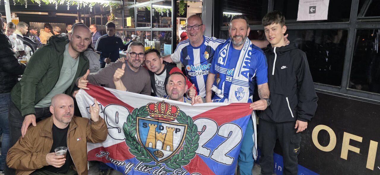Grupo de aficionados de la Ponferradina celebrando con una bandera