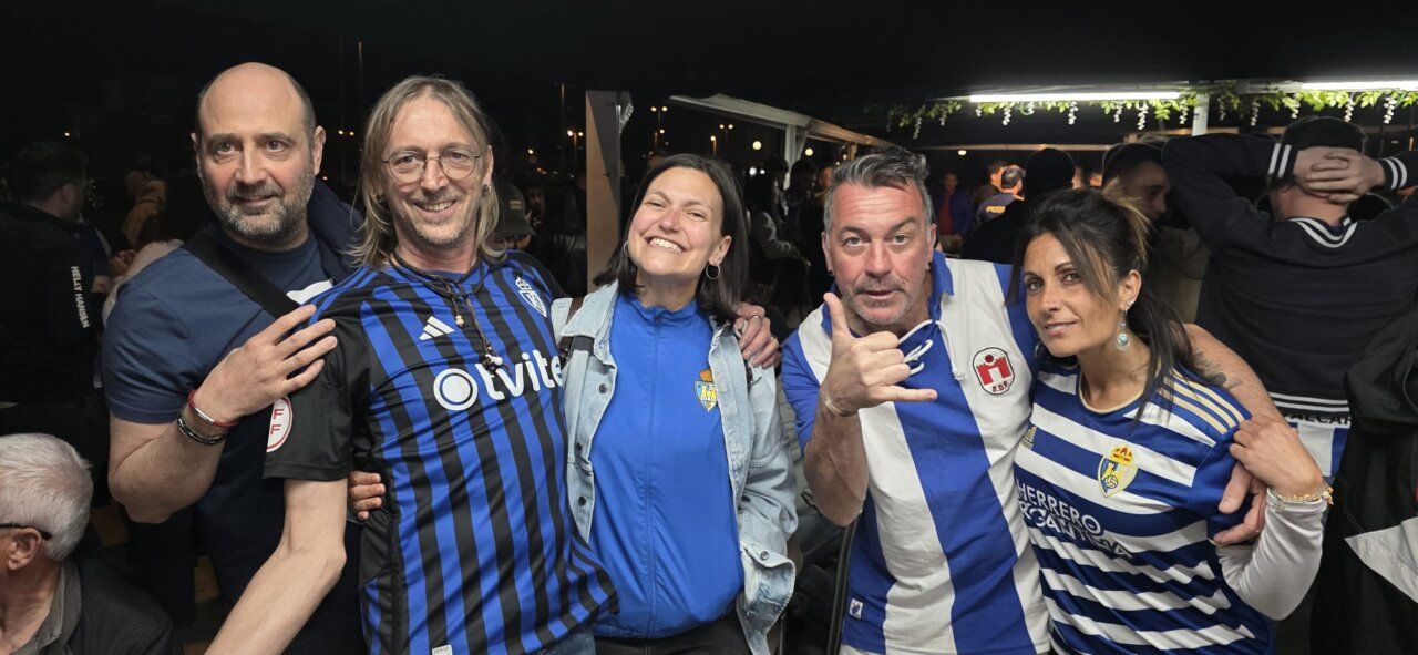 Grupo de aficionados celebrando en un evento deportivo