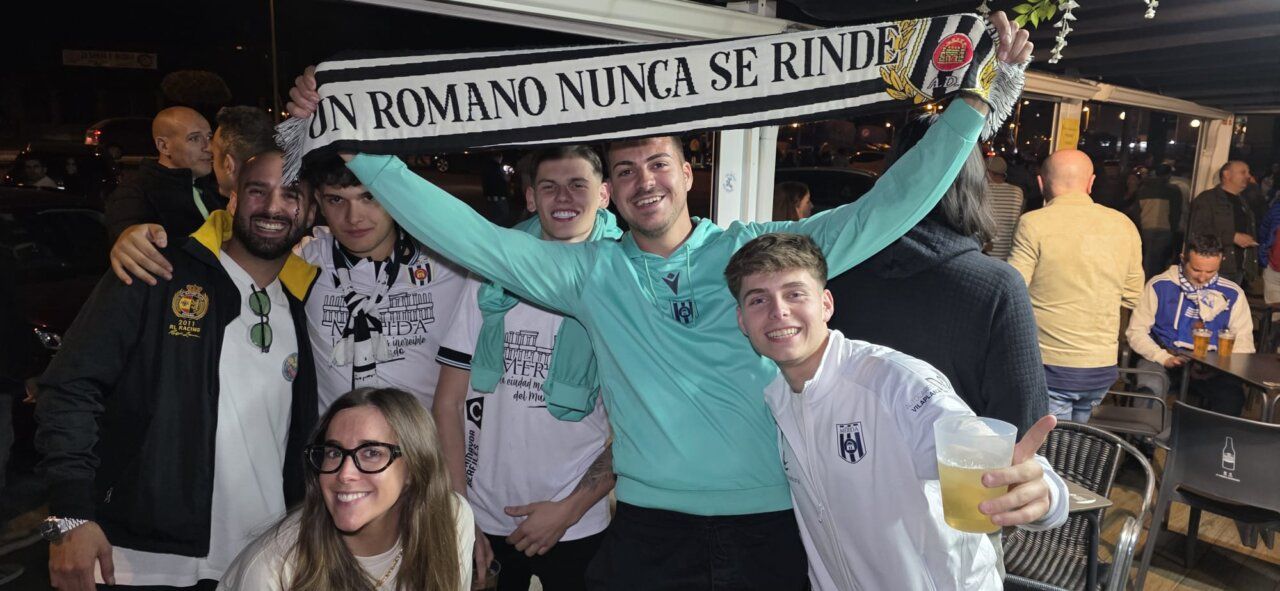 Grupo de amigos celebrando con bufanda en un bar