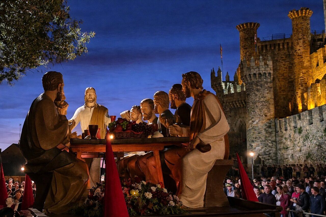 Escena de la procesión de la Santa Cena con figuras religiosas y castillo de fondo