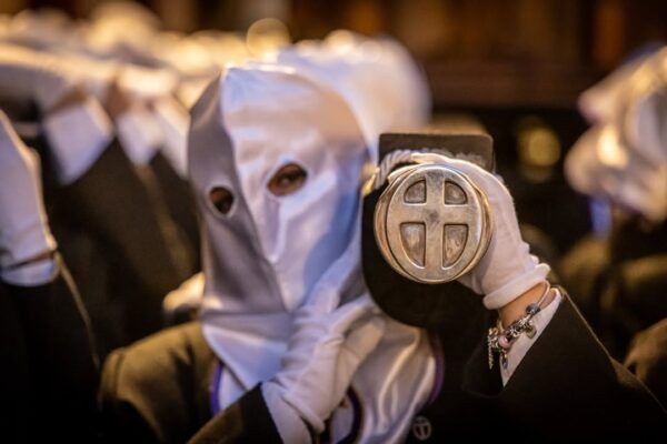 Participante de la Procesión del Silencio en La Bañeza con capucha y cruz