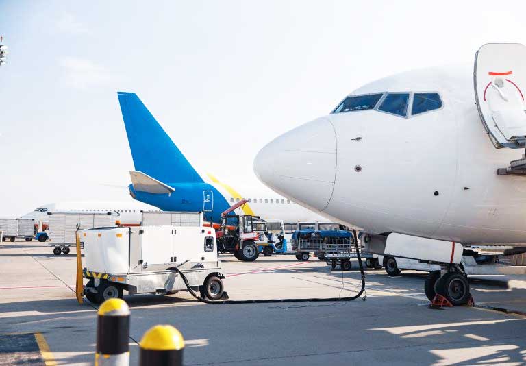 Avión en el aeropuerto con camiones de carga y equipamiento