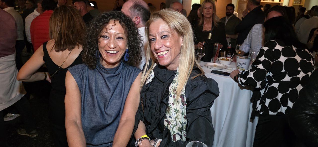 Dos mujeres sonriendo en una celebración de aniversario en un casino.