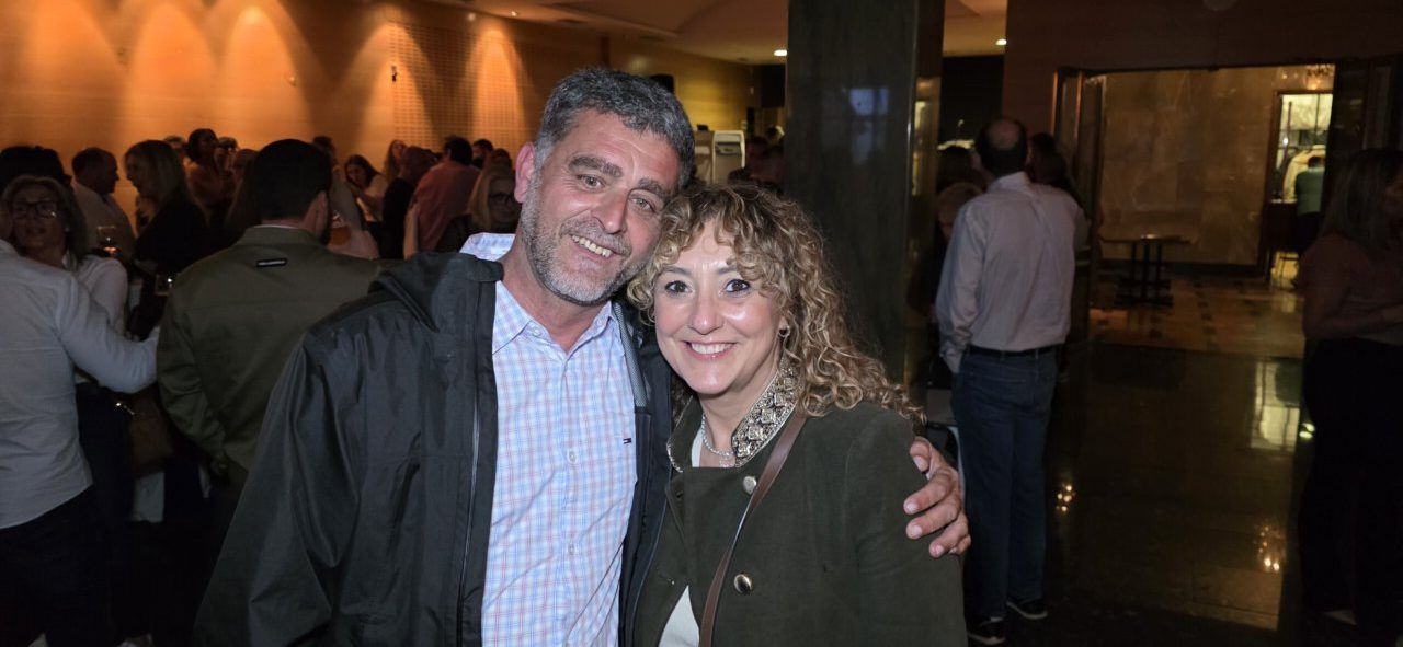 Dos personas sonriendo en un evento de aniversario en un casino.