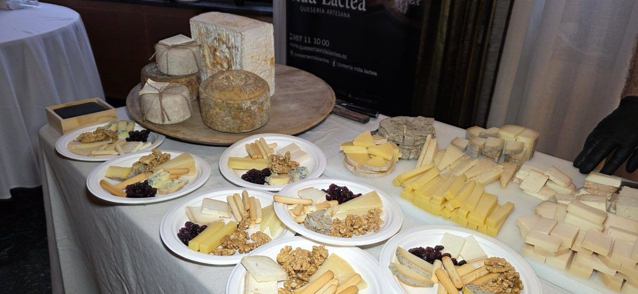 Mesa con variedad de quesos y aperitivos en un evento