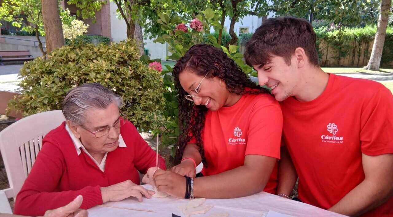 Jóvenes voluntarios interactuando con una persona mayor en un programa intergeneracional