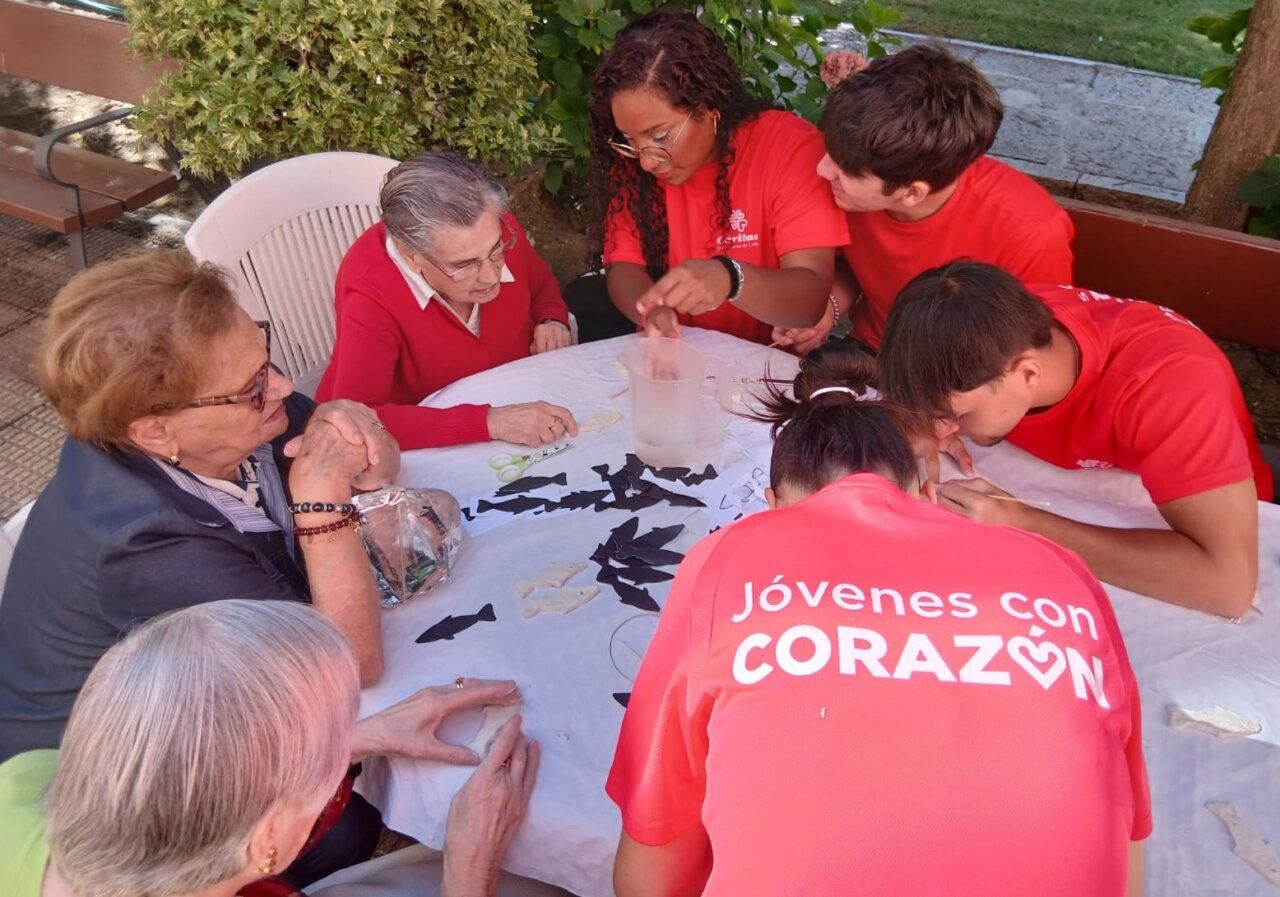 Jóvenes y mayores interactuando en actividad intergeneracional al aire libre