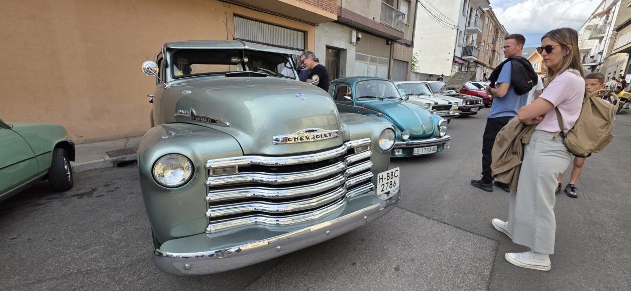 Concentración de coches clásicos en Cuatrovientos con asistentes admirando vehículos