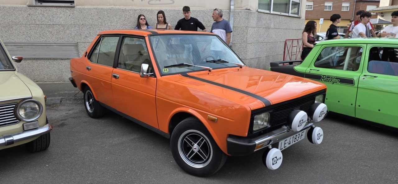 Coches clásicos en la concentración de Cuatrovientos con un ambiente animado.