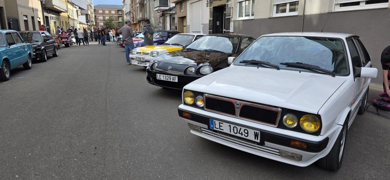Concentración de coches clásicos en Cuatrovientos con varios vehículos en la calle.