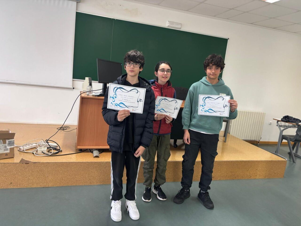 Estudiantes sosteniendo certificados en el I Concurso de Ortografía Intercentros en Ponferrada