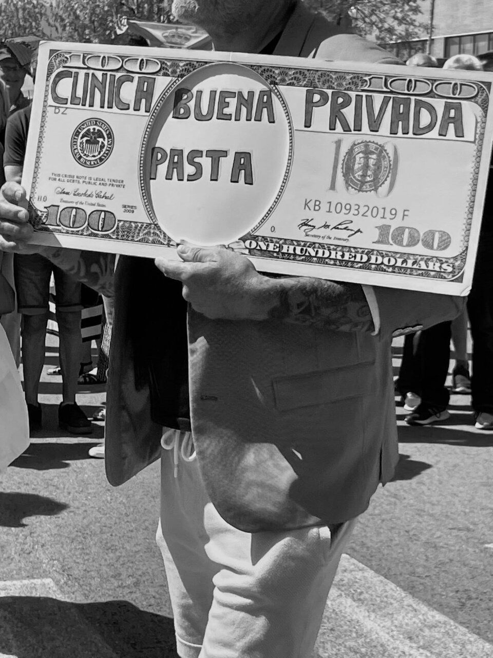 Persona sosteniendo un cartel que critica la sanidad privada.