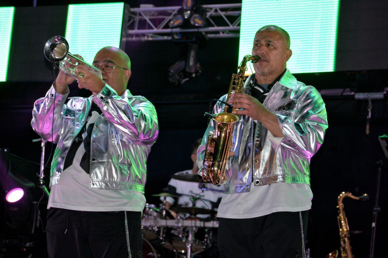 Músicos de la Orquesta Solara tocando instrumentos en un evento festivo.