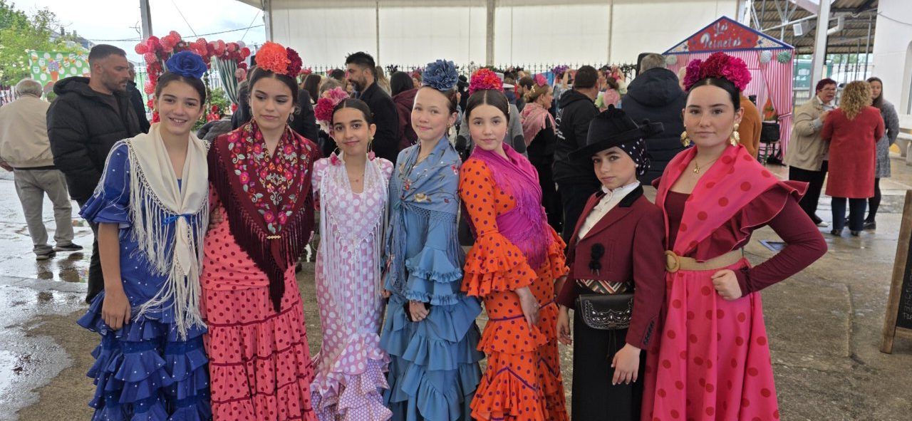 Grupo de jóvenes vestidas con trajes de sevillanas en la Feria del Caballo.