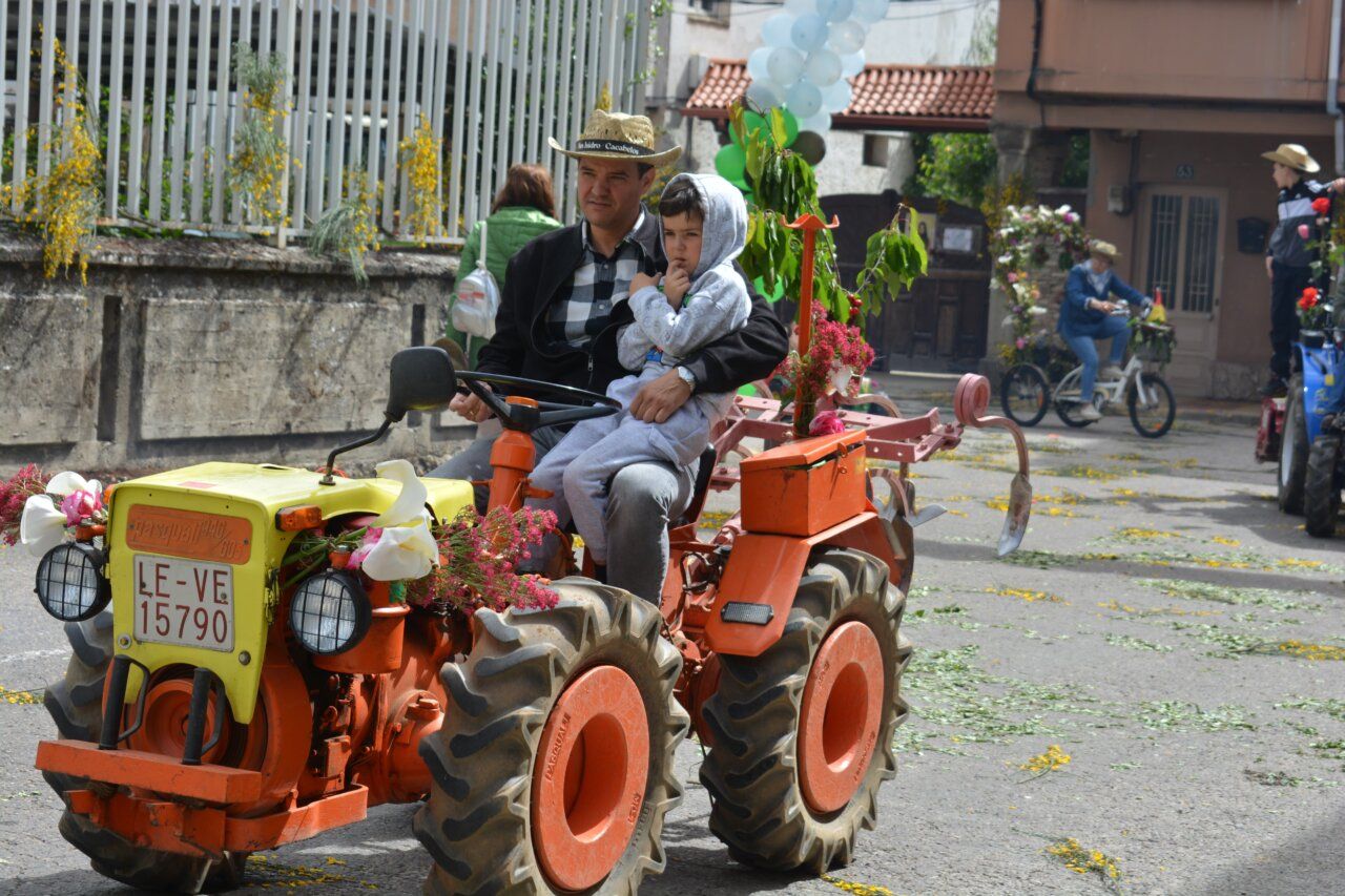 Hombre y niño en un tractor decorado durante la fiesta de San Isidro en Cacabelos