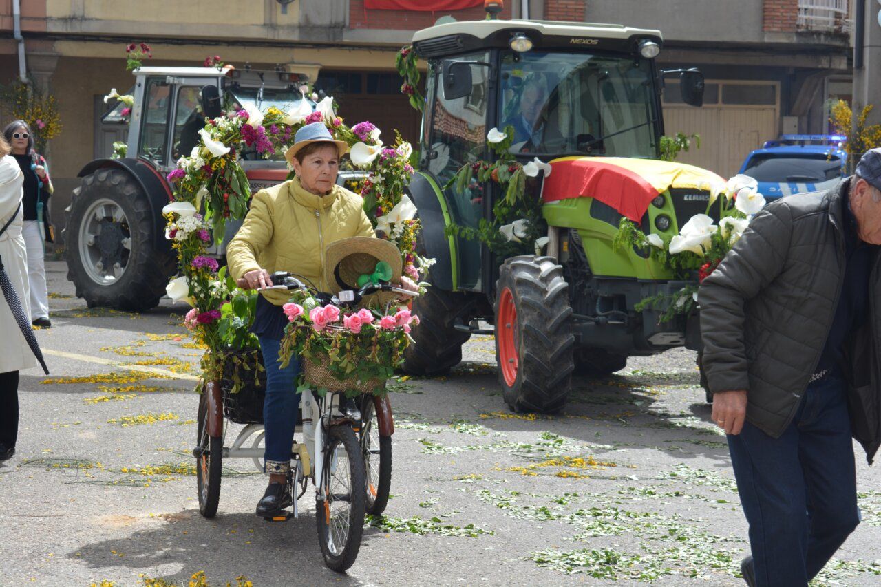 Mujer en bicicleta decorada con flores durante la fiesta de San Isidro en Cacabelos