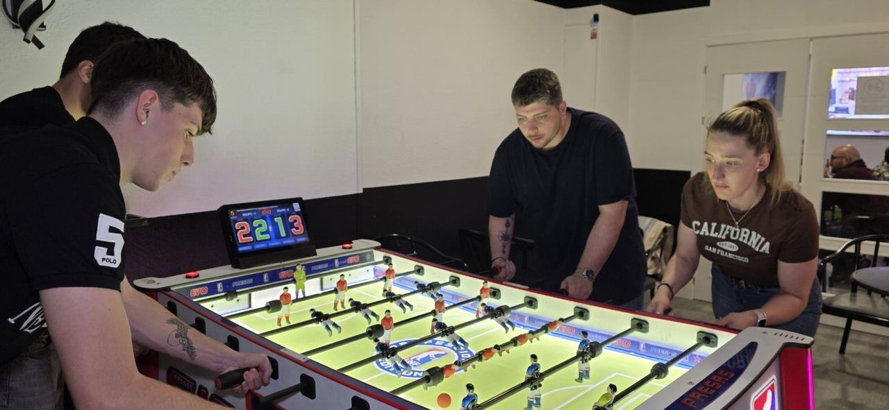 Participantes disfrutando del juego de futbolín en Bar Sueños