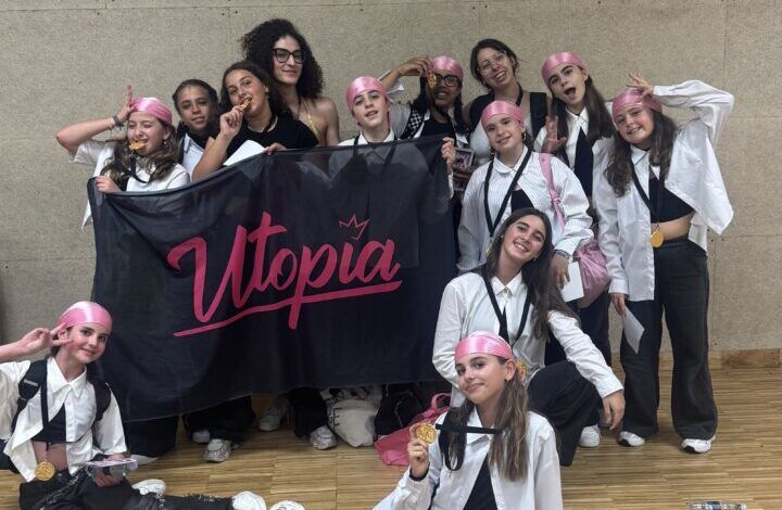 Grupo de bailarines de Utopía Dance Studio con medallas y bandera