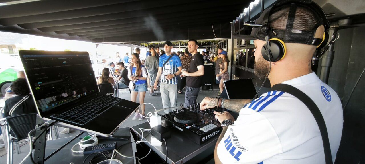 DJ tocando en un bar con gente disfrutando