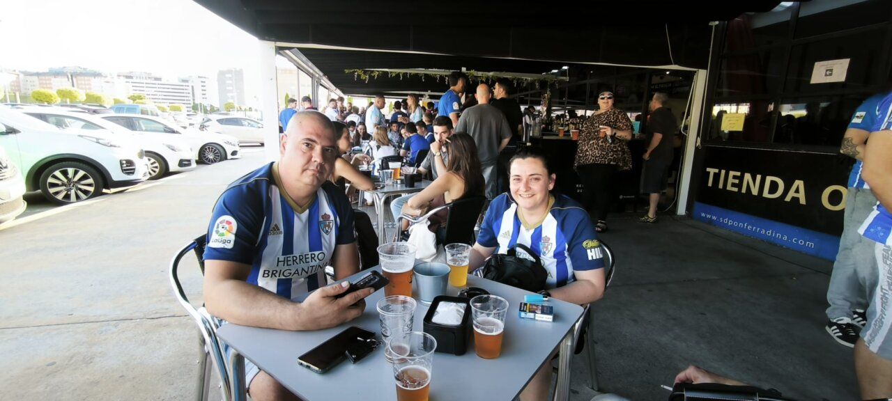 Dos personas sentadas en una mesa con cervezas en un bar