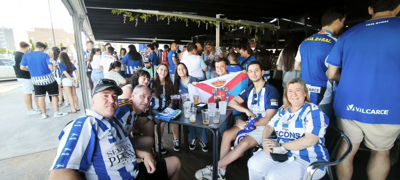 Grupo de aficionados en un bar apoyando al equipo de fútbol