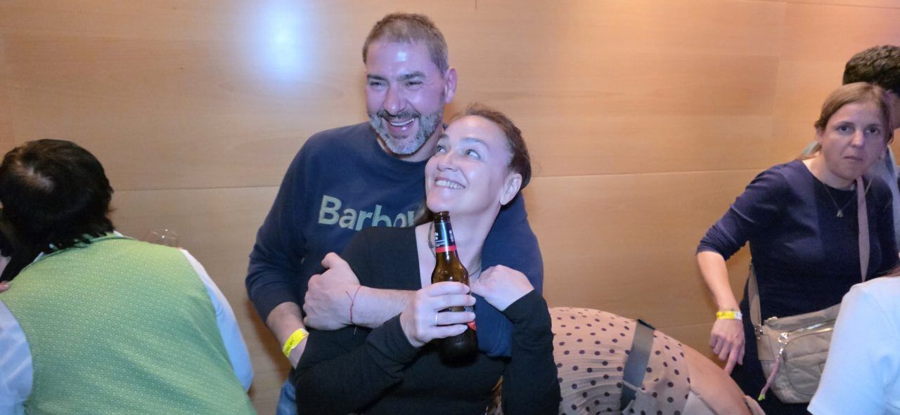 Dos personas sonriendo y celebrando en un evento social.