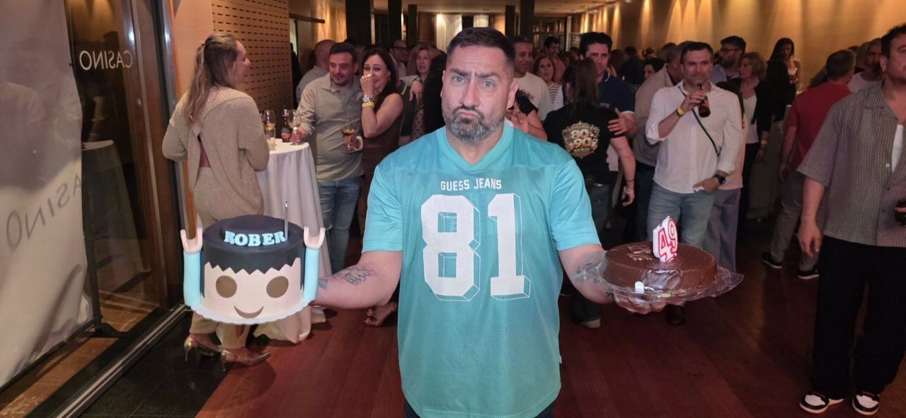 Hombre sosteniendo dos pasteles en una fiesta de aniversario
