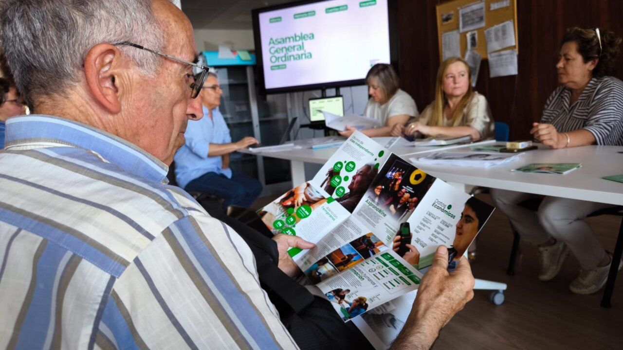 Persona mayor revisando documentos en la asamblea de Asprona Bierzo