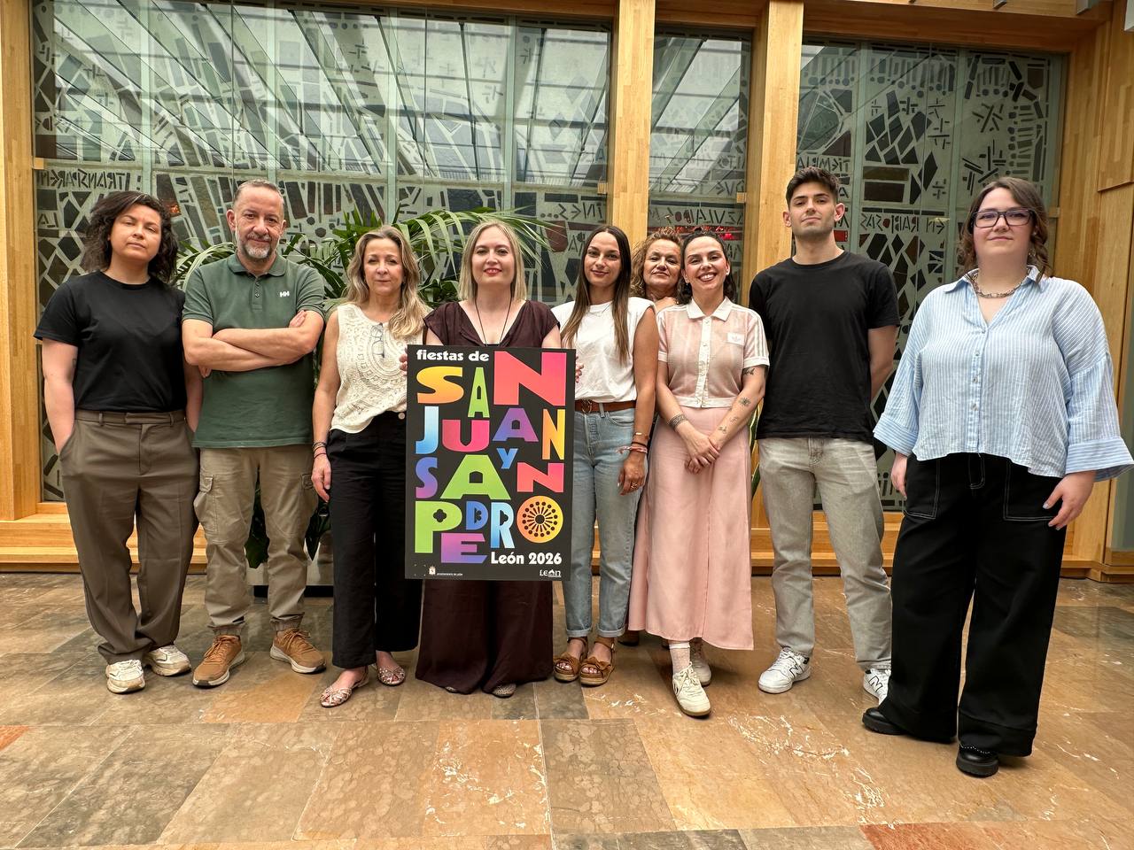 Grupo de personas presentando el cartel de las fiestas de San Juan y San Pedro 2026 en León