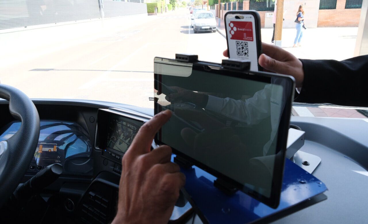 Pantalla de bus con dispositivo móvil mostrando código QR para transporte interurbano