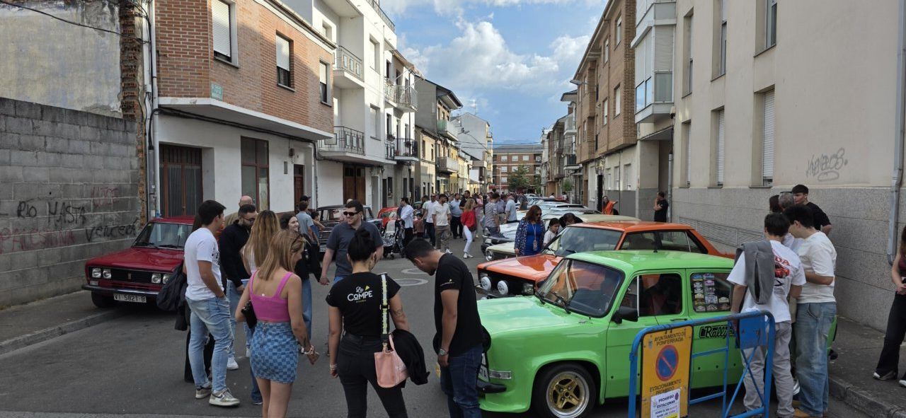 Concentración de coches clásicos en Cuatrovientos con asistentes disfrutando del evento.