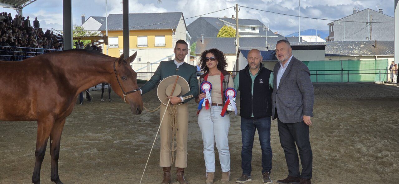 Cuatro personas en un evento ecuestre con un caballo y premios
