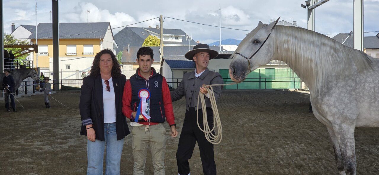 Tres personas posando con un caballo en un evento ecuestre