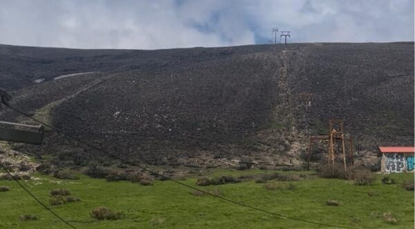 Vista de la estación de montaña El Morredero con vegetación y estructuras abandonadas.