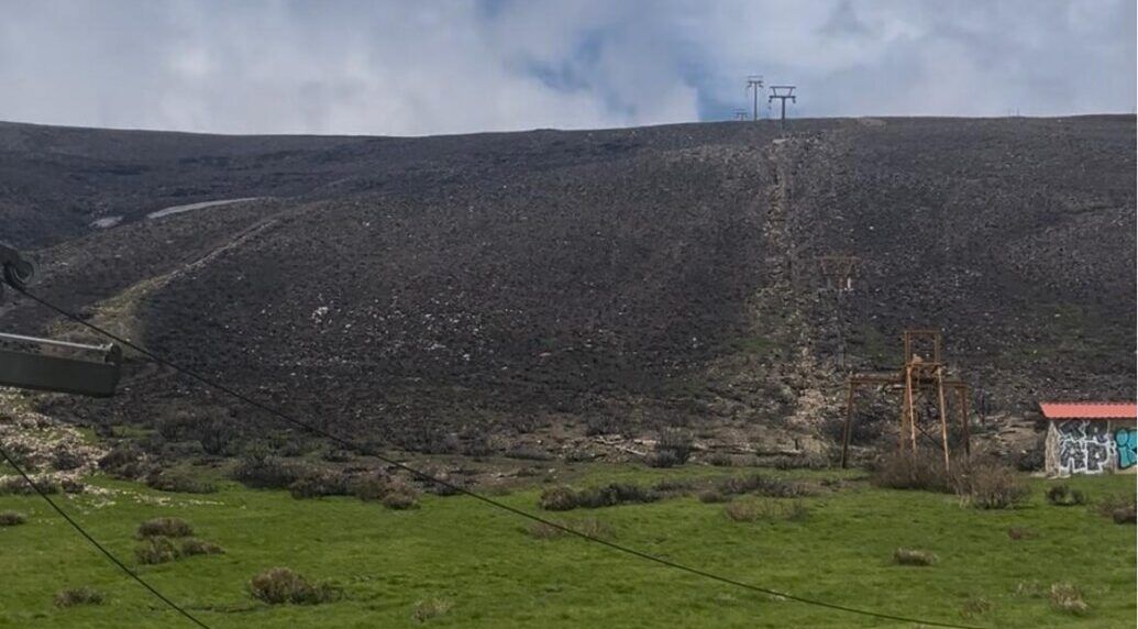 Vista de la estación de montaña El Morredero con vegetación y estructuras abandonadas.