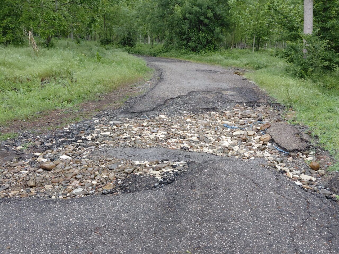 Camino en Dehesas con deterioro y piedras visibles en la superficie