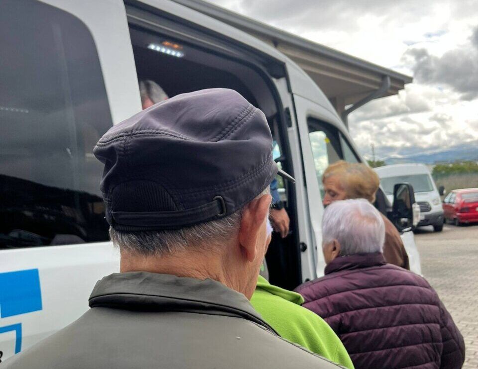 Personas mayores abordando un vehículo durante una celebración comunitaria