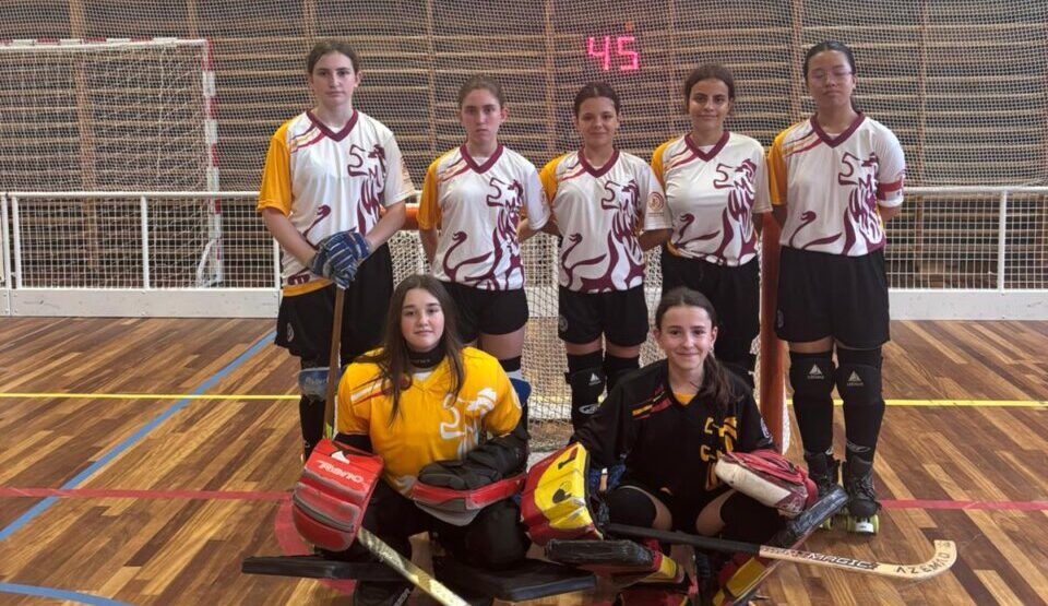 Equipo femenino de hockey sobre patines posando en la cancha