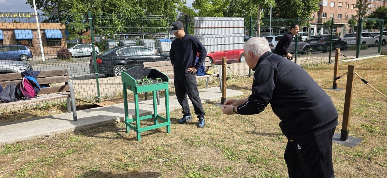 Personas jugando a los bolos en un parque al aire libre