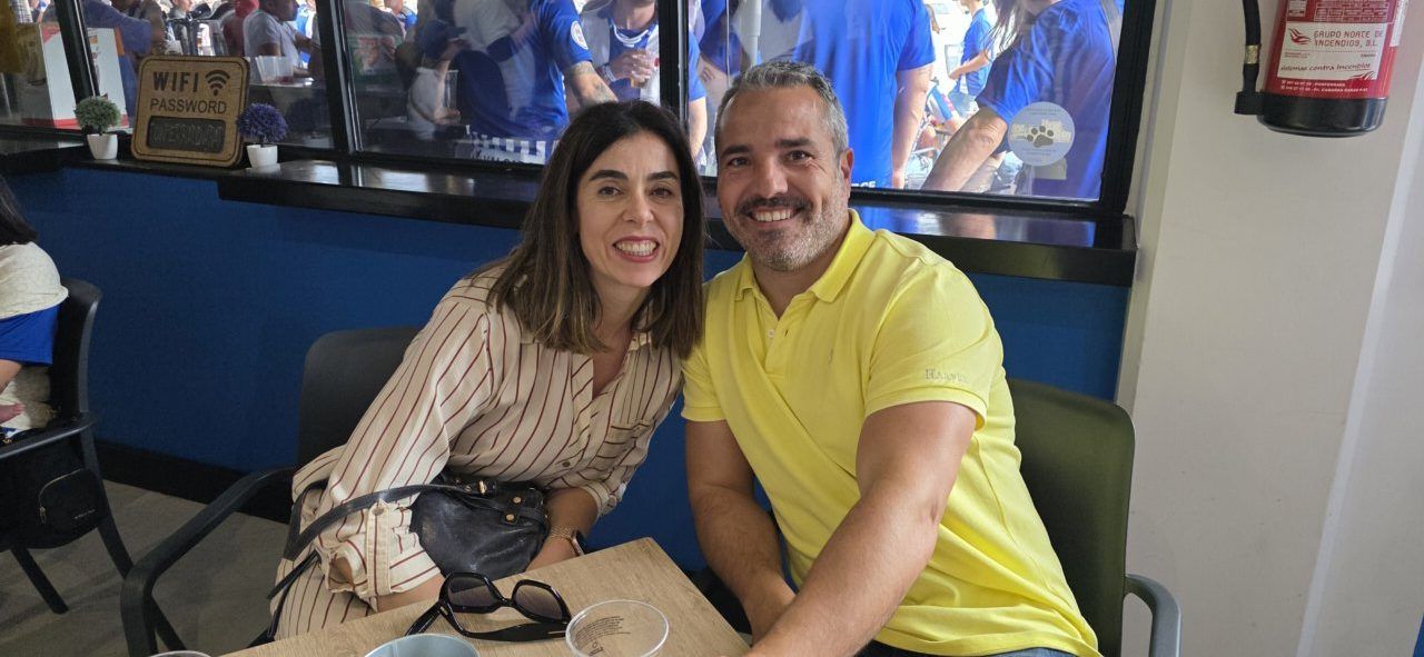 Pareja sonriente en un bar durante un evento deportivo
