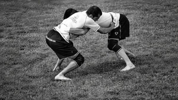 Dos luchadores en un combate de lucha leonesa en el campo