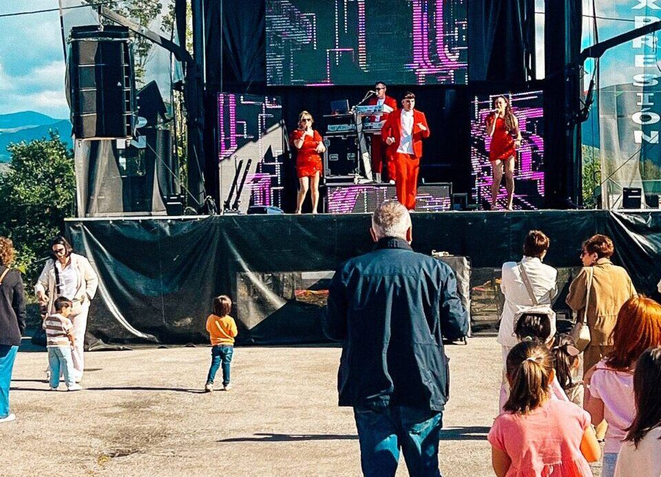 Actuación musical en un evento festivo con público disfrutando.