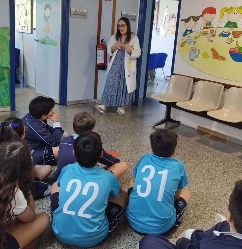Estudiantes escuchando a una profesional de la salud en un centro educativo