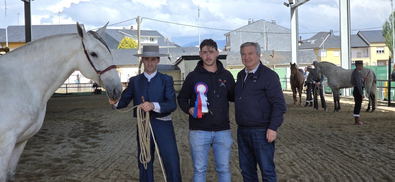 Ganadores de un concurso ecuestre con un caballo blanco