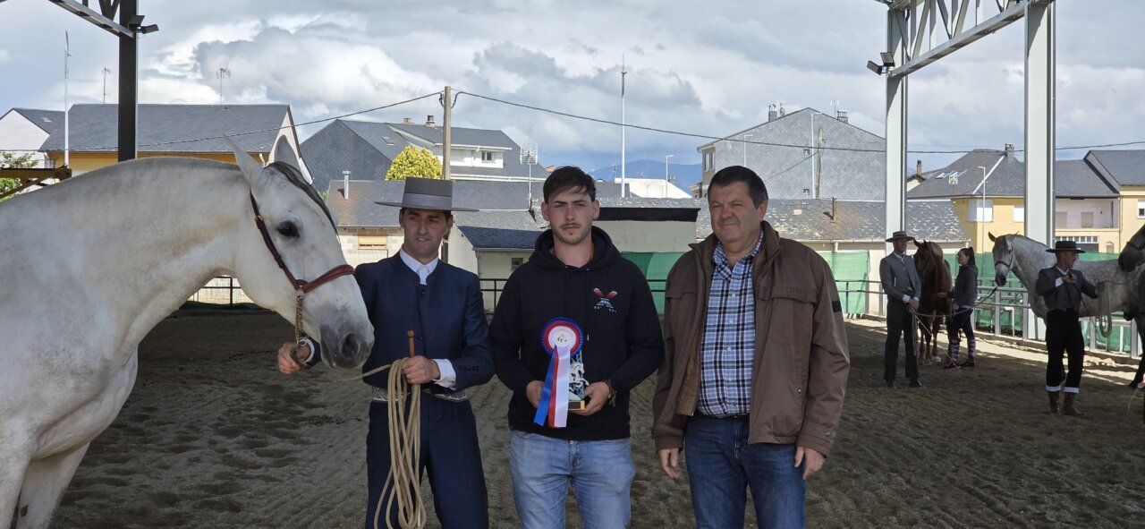 Participantes en un evento ecuestre con un caballo y trofeo
